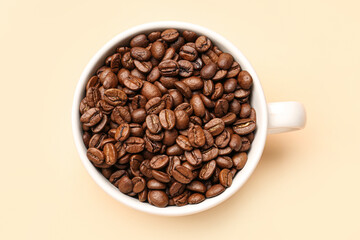 Cup with aromatic coffee beans on pale yellow background
