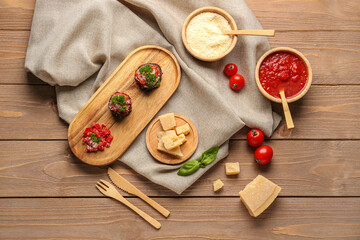 Plate with tasty baked Eggplant Parmesan and ingredients on wooden background