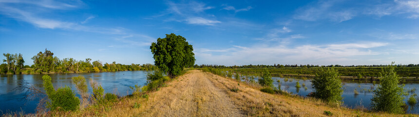 Fototapeta na wymiar Panorama of a levee road with water on both sides 