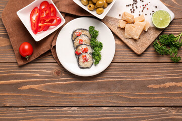 Plate with tasty baked Eggplant Parmesan and ingredients on wooden background