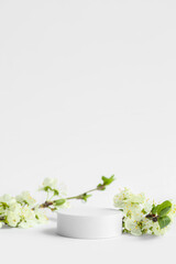 Decorative podiums and blooming branches on white background