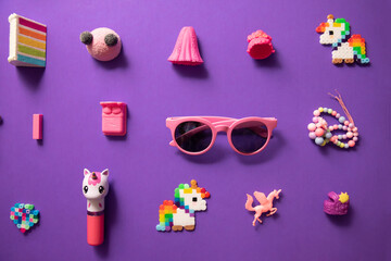Wallpaper of  eclectic pink kid toys in a pattern shot top down on a purple  background