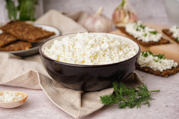 Bowl with tasty cottage cheese on light grunge background