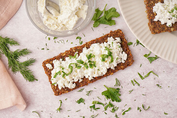 Tasty cottage cheese and rye bread on light grunge background