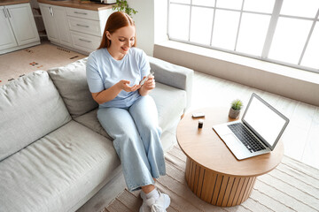 Woman with diabetes taking blood sample at home