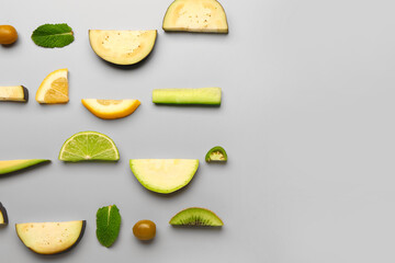 Composition with green fresh fruits and vegetables on grey background