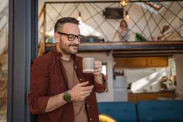 Happy 40-Year-Old caucasian Man Enjoying Tea or coffee on Balcony