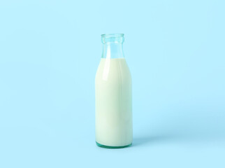Bottle of milk on light blue background