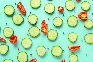 Slices of cucumber with dried tomatoes on turquoise background