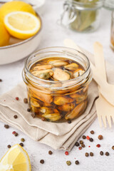 Jar with pickled mussels on white background