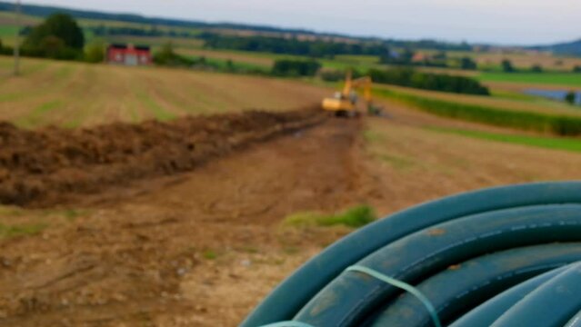 Plumbing installation.Pipe laying.Water pipes and yellow excavator in the field. Carrying out water construction work.Bringing water to the house. High quality 4k footage Generative AI