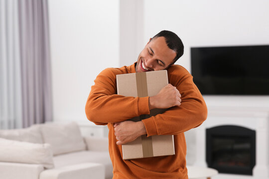 Happy Young Man With Parcel At Home. Internet Shopping