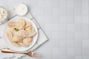 Delicious dumplings (varenyky) with cottage cheese served on white table, flat lay. Space for text