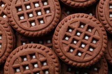 Tasty chocolate sandwich cookies with cream as background, top view