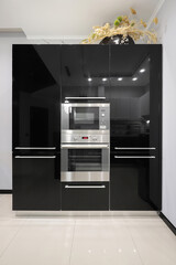 Black kitchen furniture with built-in microwave and electric oven