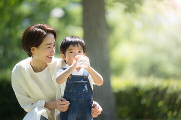 夏の水分補給の親子のイメージ　右にコピースペースあり