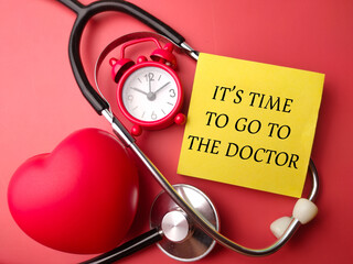 Stethoscope and alarm clock with the word ITS TIME TO GO THE DOCTOR