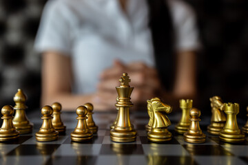 Woman playing chess, Woman hand holds chess piece on dark background, Hand business woman moving chess for business challenge.