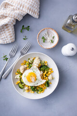 Healthy breakfast bowl with cooked vegetables and fried egg