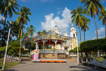 Colonial kiosk in the center of the park in Villa de Alvarez, Colima, Mexico, decorated with a huge catrina, cempasúchil flowers and the traditional papel picado.