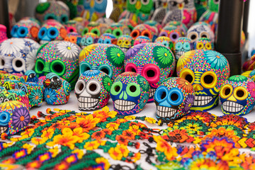 Fototapeta na wymiar Colorful skulls, Mexican handicrafts. Day of the Dead, handmade Huichol figure made of chaquira, Mexico.