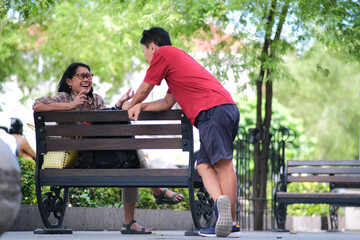Adult couple chatting on a park bench on a road side