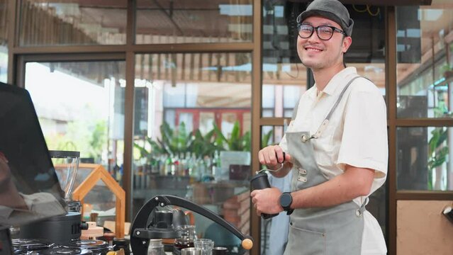 Portrait of Asian attractive barista or waiter working in coffeehouse.