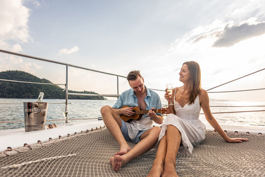 Caucasian young couple drinking champagne while having party in yacht. 