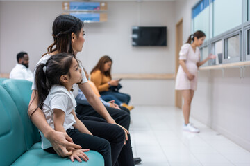 Asian family patient wait on line queue to receive medicine in hospital.