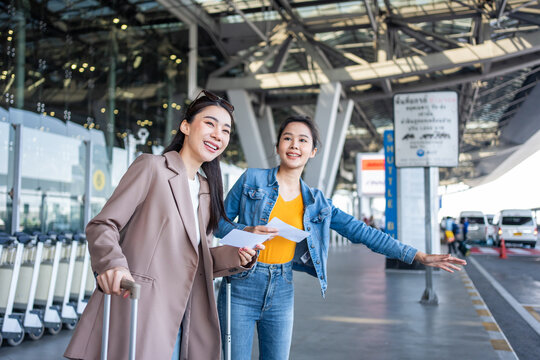 Asian Two Women Passenger Waiting A Bus After Leaving From The Airport.