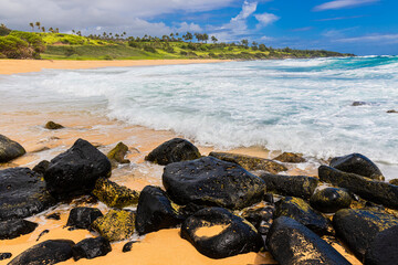 Waves Washing Over Lava Rocks on The Sandy Shore of Donkey Beach, Kauai, Hawaii, USA