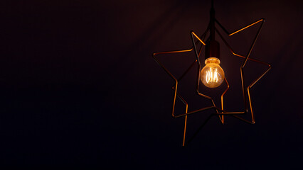 Vintage incandescent light bulb filament on black, close up shot