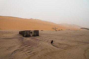 Fototapeta na wymiar Old wooden fishing hut buried in sand of Skeleton Coast Namibia