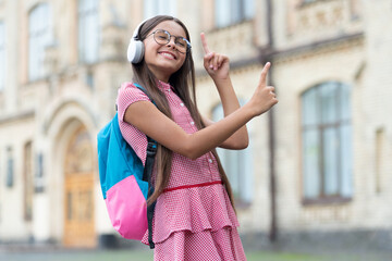 photo of school girl listen music, point finger. school girl listen music.