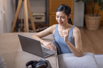 Fototapeta na wymiar Beautiful Young Asian woman using laptop computer on sofa at home, shopping online with internet in happy mood and Relax part time concept 