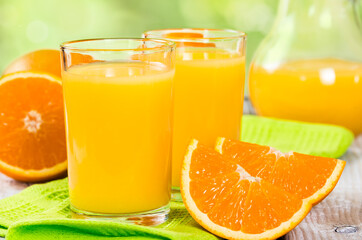 Naklejka na ściany i meble Fresh orange juice on a wooden background