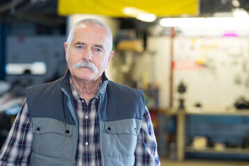 Obraz premium portrait of elderly garage technician