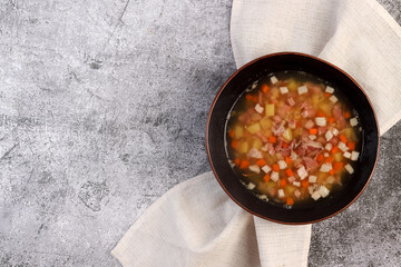 Split pea soup with beef, potatoes and carrots in bowl on a dark gray background. Top view, flat lay.