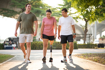 Exercise walking Asia woman with prosthetic leg and friend in the park	