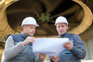 engineer and foreman pointing to drawing paper