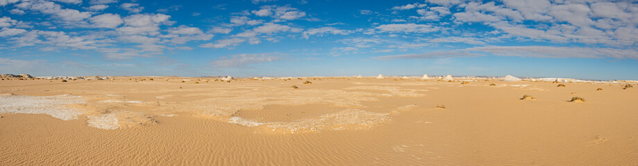 Barren sandy desert landscape in hot climate with rock formation