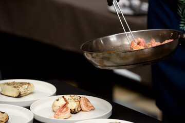 chef in the restaurant prepares saganaki, traditional Greek cheese snack that is fried in a pan or grilled