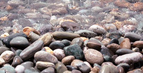 Stone pebbles on the shore as an abstract background. Texture.