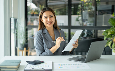 Asian businesswoman sit at their desks and calculate financial graphs showing results about their investments, plan a successful business growth process