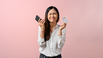 Happy young Asian woman holding smartphone and credit card