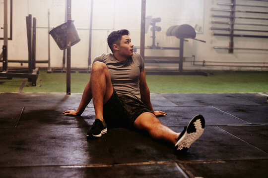 Young man looking tired after working out at the gym