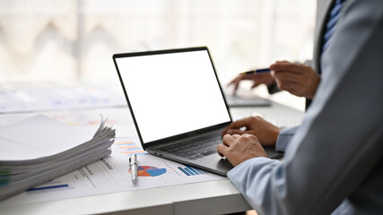 Close-up image of a businessman using his laptop while having a meeting