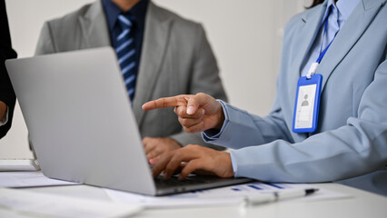 Fototapeta premium Close-up image of a professional businesswoman pointing her finger at a laptop screen