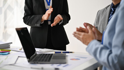 Businesspeople are applauding in the meeting to celebrate their successful project.