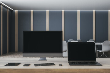 Contemporary designer office desktop with empty mock up computer screens, supplies and blurry interior background. 3D Rendering.